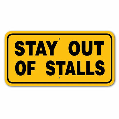 Yellow sign with black text 'STAY OUT OF STALLS' on a white background