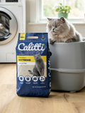Cat sitting next to a bag of Caliitti Clumping Extreme cat litter in a home setting.